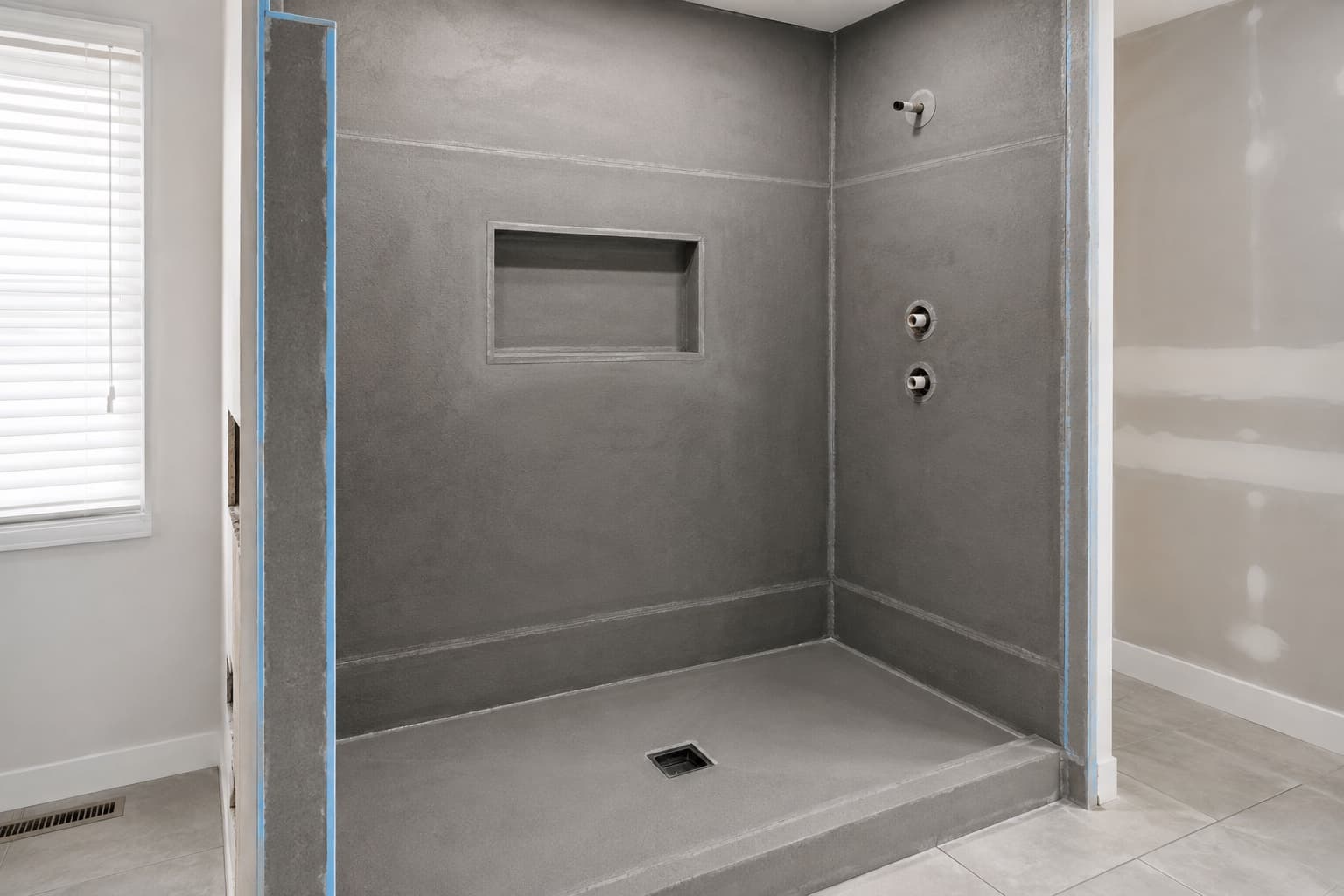 Waterproof shower assembly before tile with sealed panels, niche, sloped base, and integrated drain